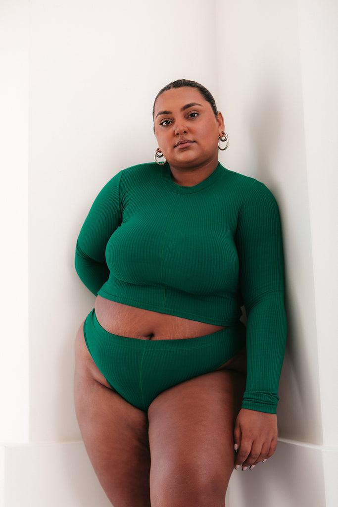 Model stands in front of wall in green loungewear set